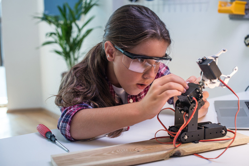 Young girl working on a STEM Project robot 
